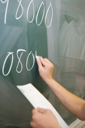 Student writing on blackboard